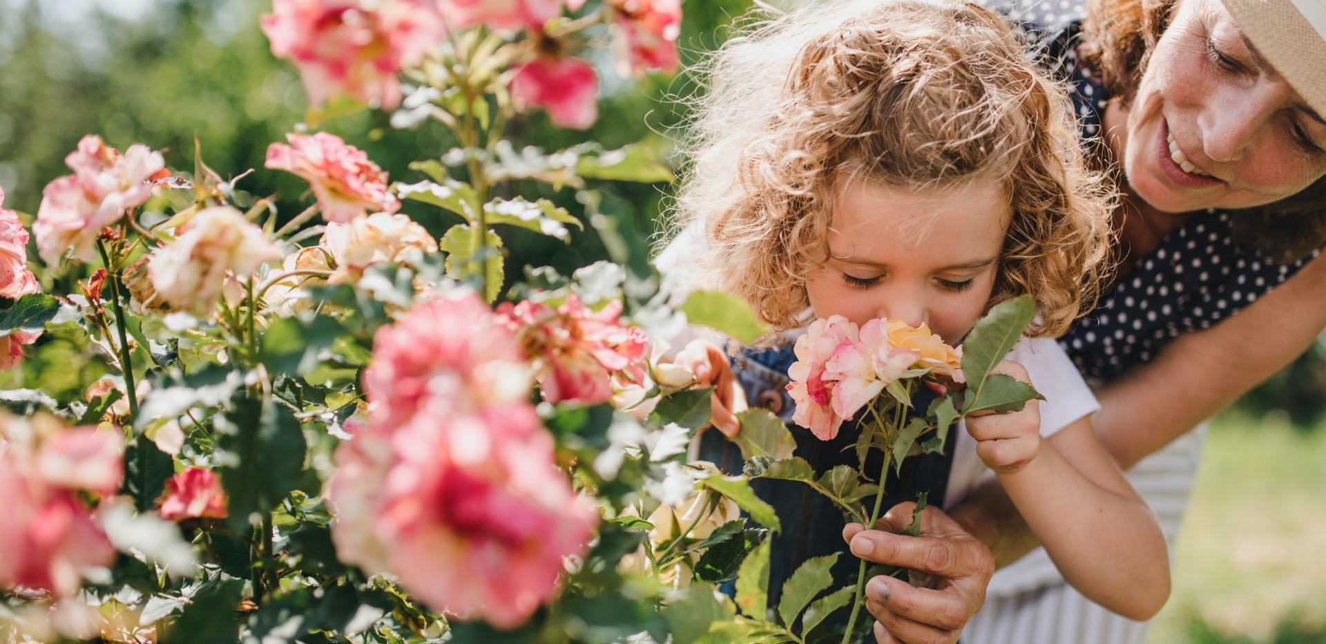 Image showing a woman and a little girl smelling flowers