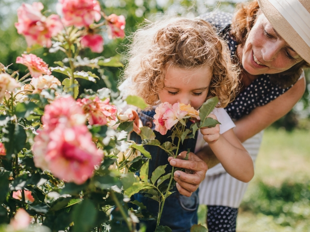 Image showing a woman and a little girl smelling flowers